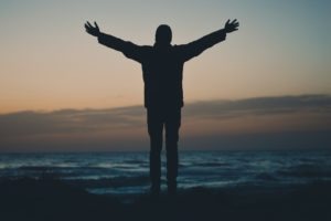 silhouette of person facing beach